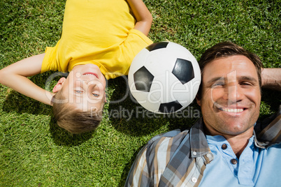 Father and son lying on grass in the park