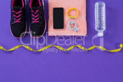 Sneakers, water bottle, towel, measuring tape mobile phone with headphones and fitness band