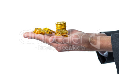 Mid section of businessman holding gold coins