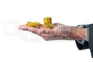 Mid section of businessman holding gold coins
