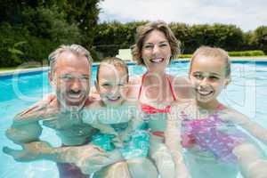 Happy parents and kids in pool