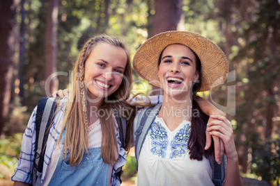 Two female friends standing together with arm around