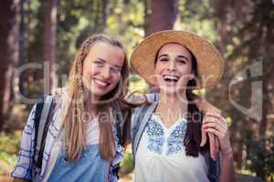 Two female friends standing together with arm around