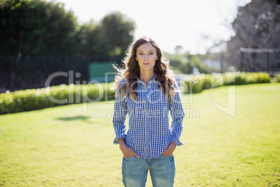 Woman standing with hands in pocket at park