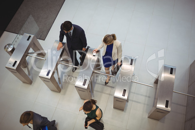 Business executives passing through turnstile gate