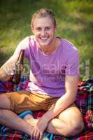 Portrait of man holding beer bottle at campsite