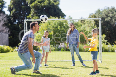 Happy family playing football in the park