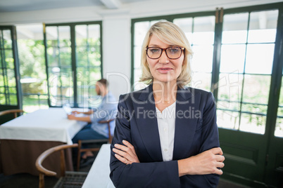 Businesswoman standing with arms crossed in a restaurant