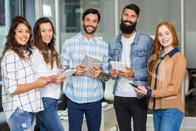 Portrait of smiling executives using digital tablet and mobile phone