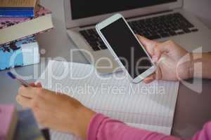 Schoolgirl using mobile phone in library