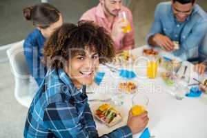 Portrait of happy male executive having breakfast