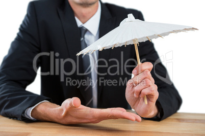 Businessman holding an paper umbrella