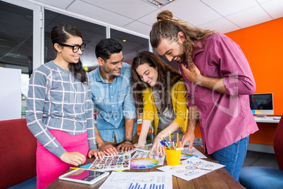 Smiling graphic designers working over photos at desk