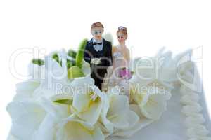 Wedding cake with couple figurines and flowers