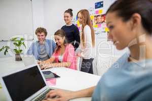 Executives discussing over laptop in office