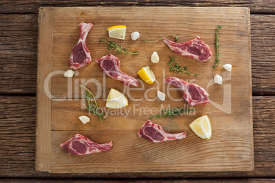 Ribs chops, lemon and garlic on wooden board