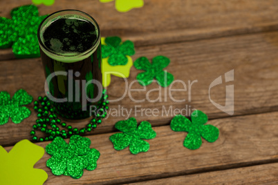 Glass of green beer, beads and shamrock for St Patricks Day