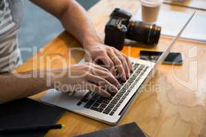 Graphic designer using laptop in creative office