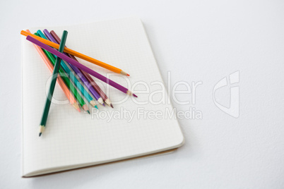 Colored pencils kept on the book