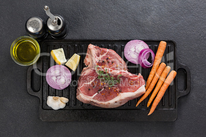 Sirloin chop and ingredients on black grill