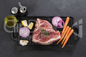Sirloin chop and ingredients on black grill