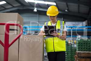 Female factory worker using a digital tablet in factory
