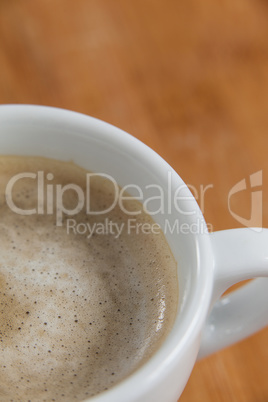 Close-up of white coffee cup with creamy froth