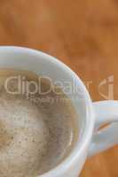 Close-up of white coffee cup with creamy froth