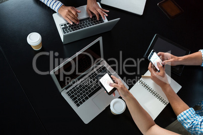 Man and women using mobile phone and laptop