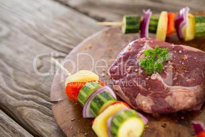 Sirloin chop with skewered vegetables on wooden tray