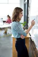 Attentive businesswoman writing on glass