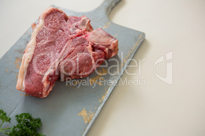 Sirloin chop on wooden board against white background