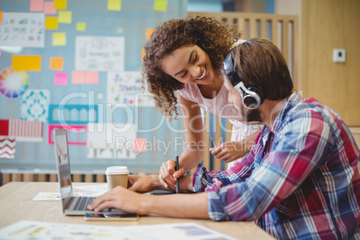 Graphic designers discussing over laptop