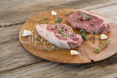 Sirloin steak, garlic and herb on wooden tray against wooden background