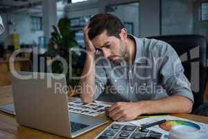 Worried man sitting with laptop at desk