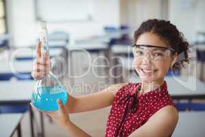 Portrait of smiling schoolgirl doing a chemical experiment in laboratory