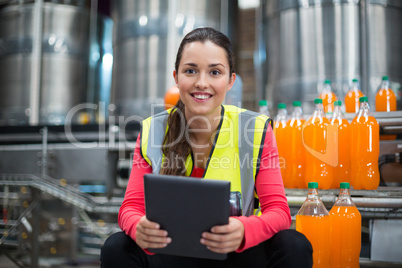 Female factory worker holding digital tablet