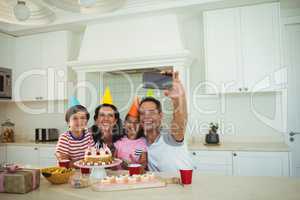 Happy family taking a selfie while celebrating a birthday
