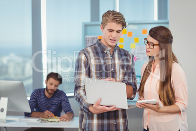 Business executives discussing over laptop