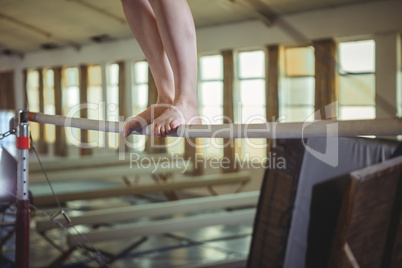 Female gymnast practicing gymnastics on the horizontal bar