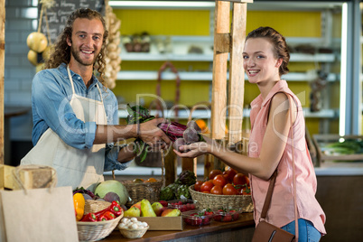 Vendor giving beetroot to the woman at the grocery store