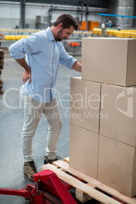 Tensed male worker standing with back pain