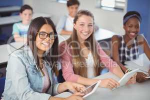 Students holding digital tablet in classroom