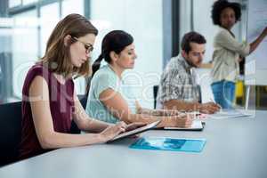 Business executive using digital tablet in meeting