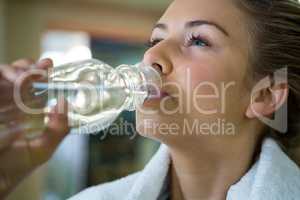 Beautiful woman drinking water after workout