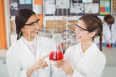 Happy schoolgirls doing a chemical experiment in laboratory