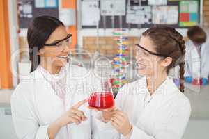 Happy schoolgirls doing a chemical experiment in laboratory