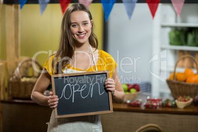 female worker holding a board with open sign