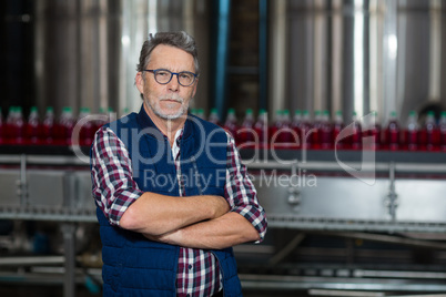Portrait of factory worker standing with his arms crossed