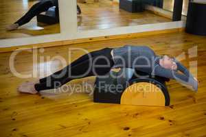 Beautiful woman exercising on arc barrel